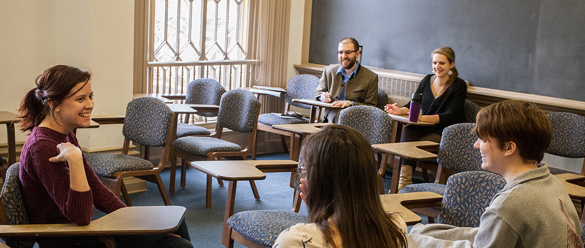 German professor Todd heidt and assistant Lisa Rabe watch as thee students take a test, consisting of an informal conversation.