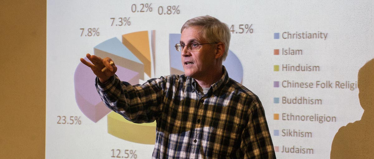 Religious studies faculty Jim Thrall leads a discussion on world religions in the Round Room of Ford Center for the Fine Arts. 