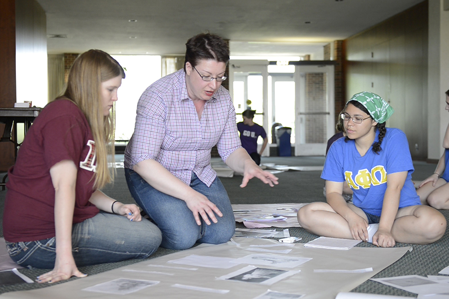Professor Catherine Denial works with students in the lobby of Ford Center of Fine Arts. 