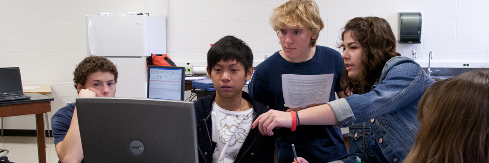 Students in a psychology class check data on a computer monitor.